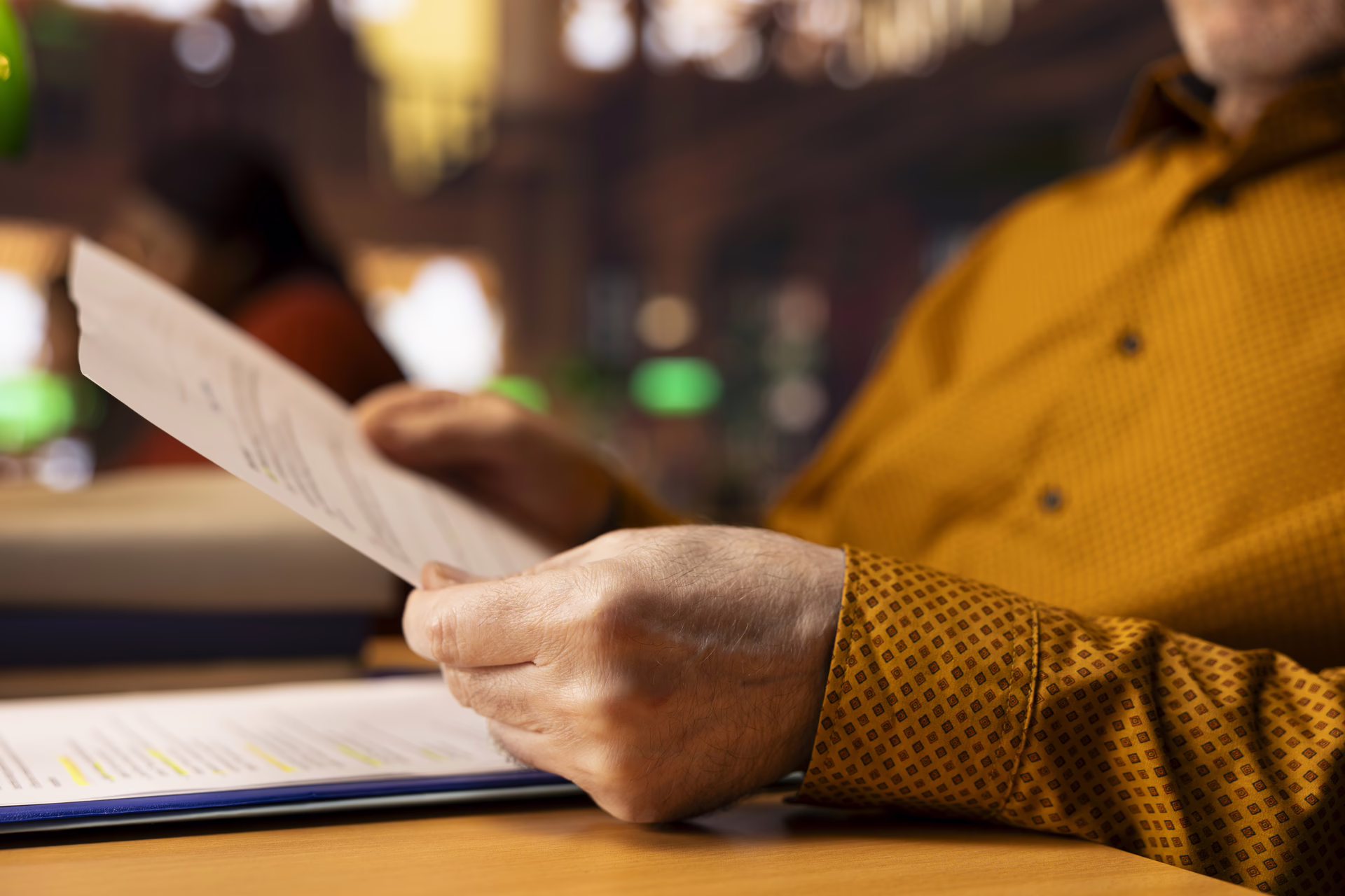 Business owner carefully reviewing franchise agreement and legal documents at desk